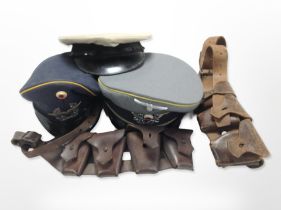 A reproduction German cap, two further caps, and two 20th-century ammunition belts.