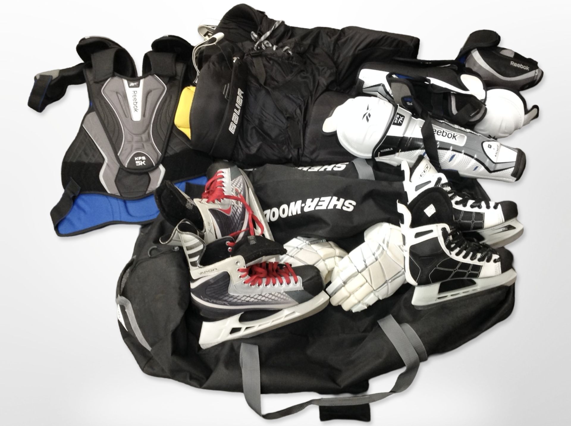 A collection of ice hockey equipment including ice skates, protective leg guards and vests, etc,