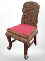 An oriental heavily carved hardwood chair, width 49cm.