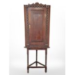 A 19th century carved oak stained pine corner cabinet on stand,