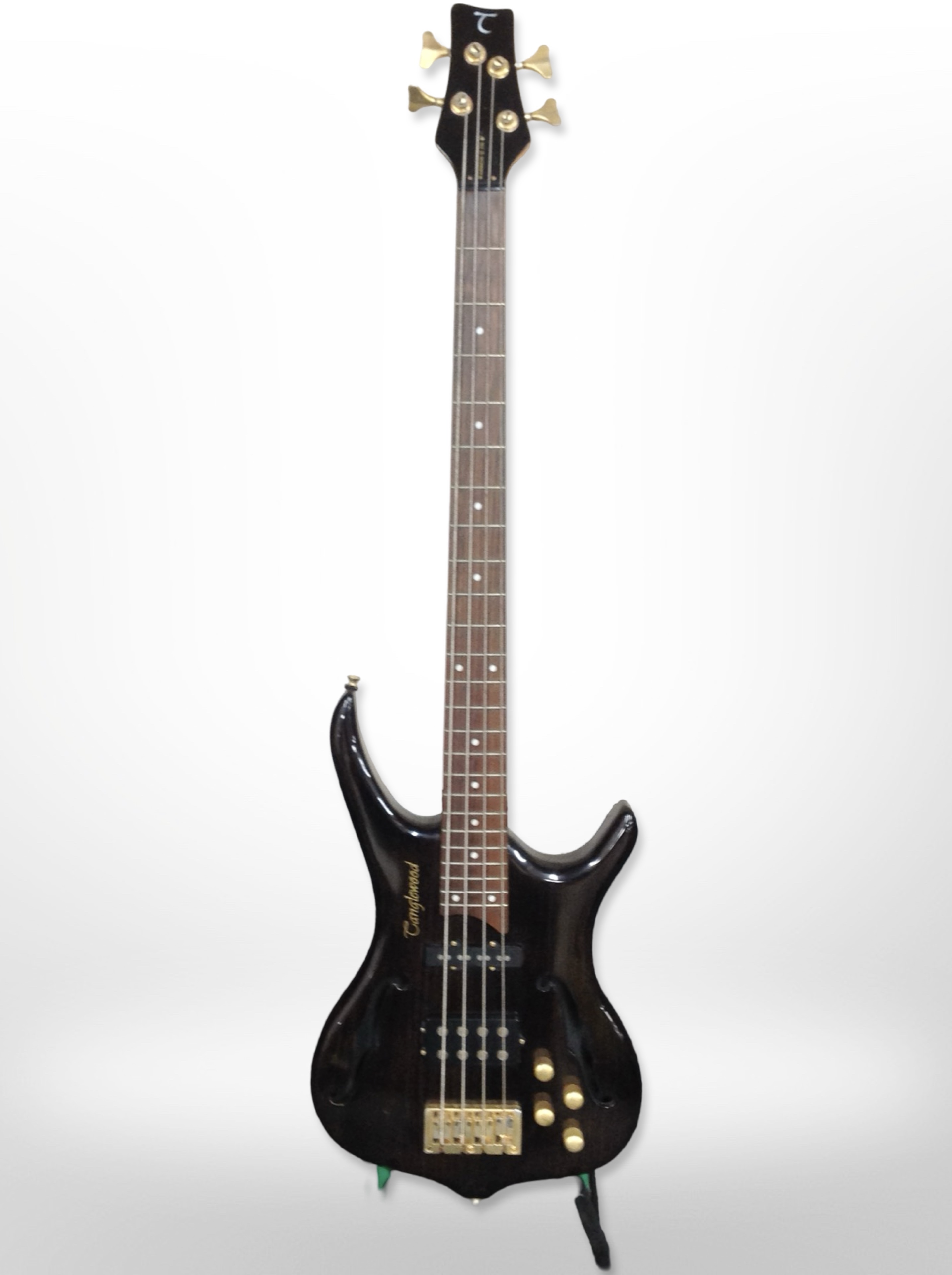A Tanglewood Warrior III bass guitar with a guitar stand.