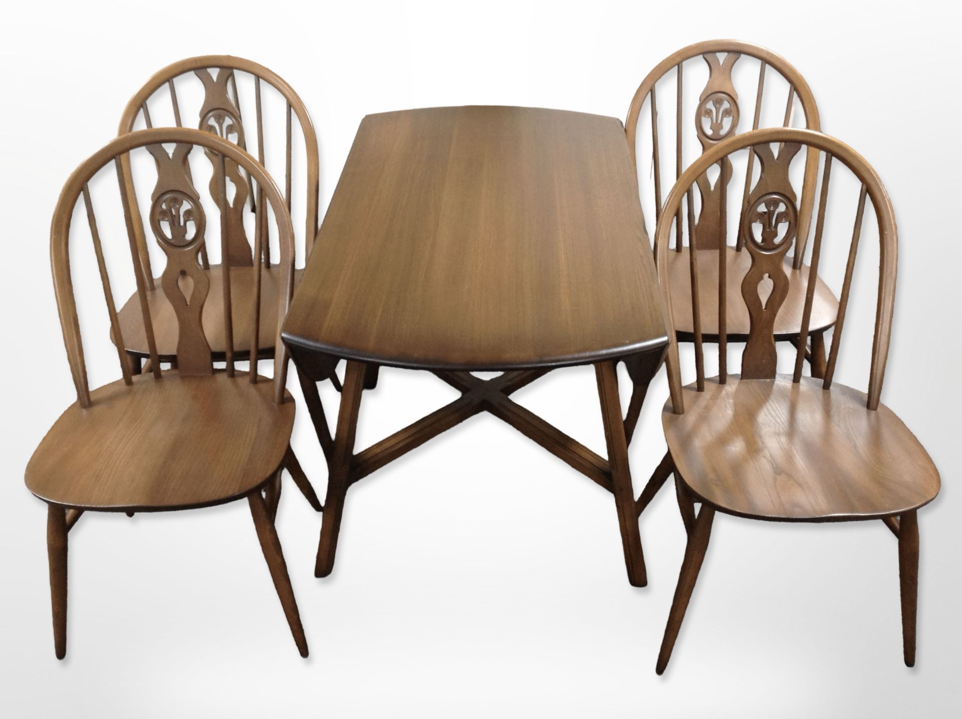 An Ercol stained elm drop leaf table and four spindle back chairs