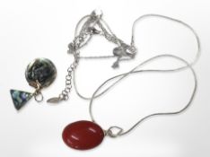 A silver-mounted red polished stone necklace and a further necklace with triangular pendant.