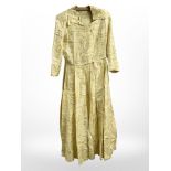 A vintage lady's circa 1950's/60's gold brocade dress and matching feathered bonnet,