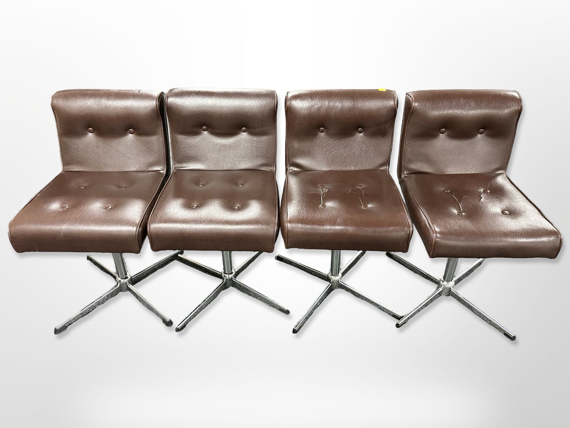 A set of four chrome and brown buttoned leather swivel chairs