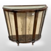 An early 20th-century walnut bow front display cabinet, 106cm wide x 32cm deep x 111cm high.
