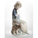 A Lladró figure of a girl holding a lamb with a dog at her feet.
