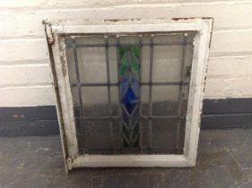 A painted metal framed stained glass window overall 46 cm x 52 cm