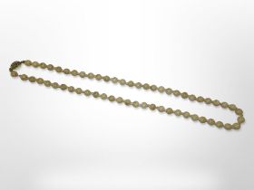 An antique mutton fat jade beaded necklace with silver gilt clasp,