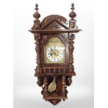 An early 20th century walnut eight day wall clock in bobbin turned case,