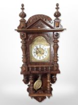 An early 20th century walnut eight day wall clock in bobbin turned case,
