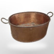 A copper twin handled cooking pot,