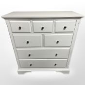 A contemporary white seven drawer chest,