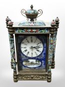 A champleve enamel mantel clock containing a battery movement,
