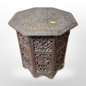 An Eastern heavily carved octagonal occasional table,
