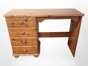 A contemporary pine four drawer single pedestal desk,