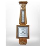 A carved oak barometer,