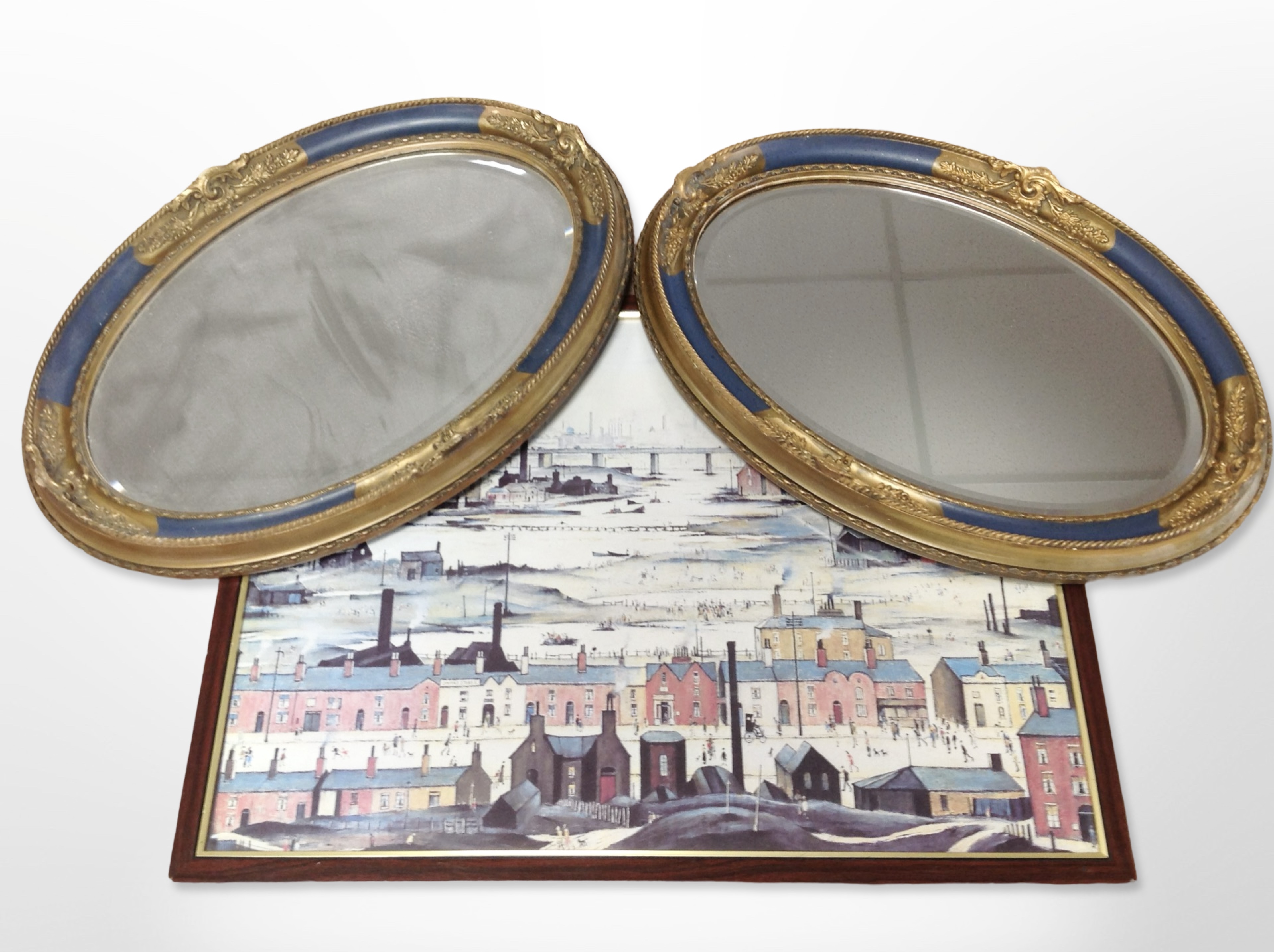 A pair of ornate gilt and gesso oval bevelled mirrors, 54cm x 37cm,