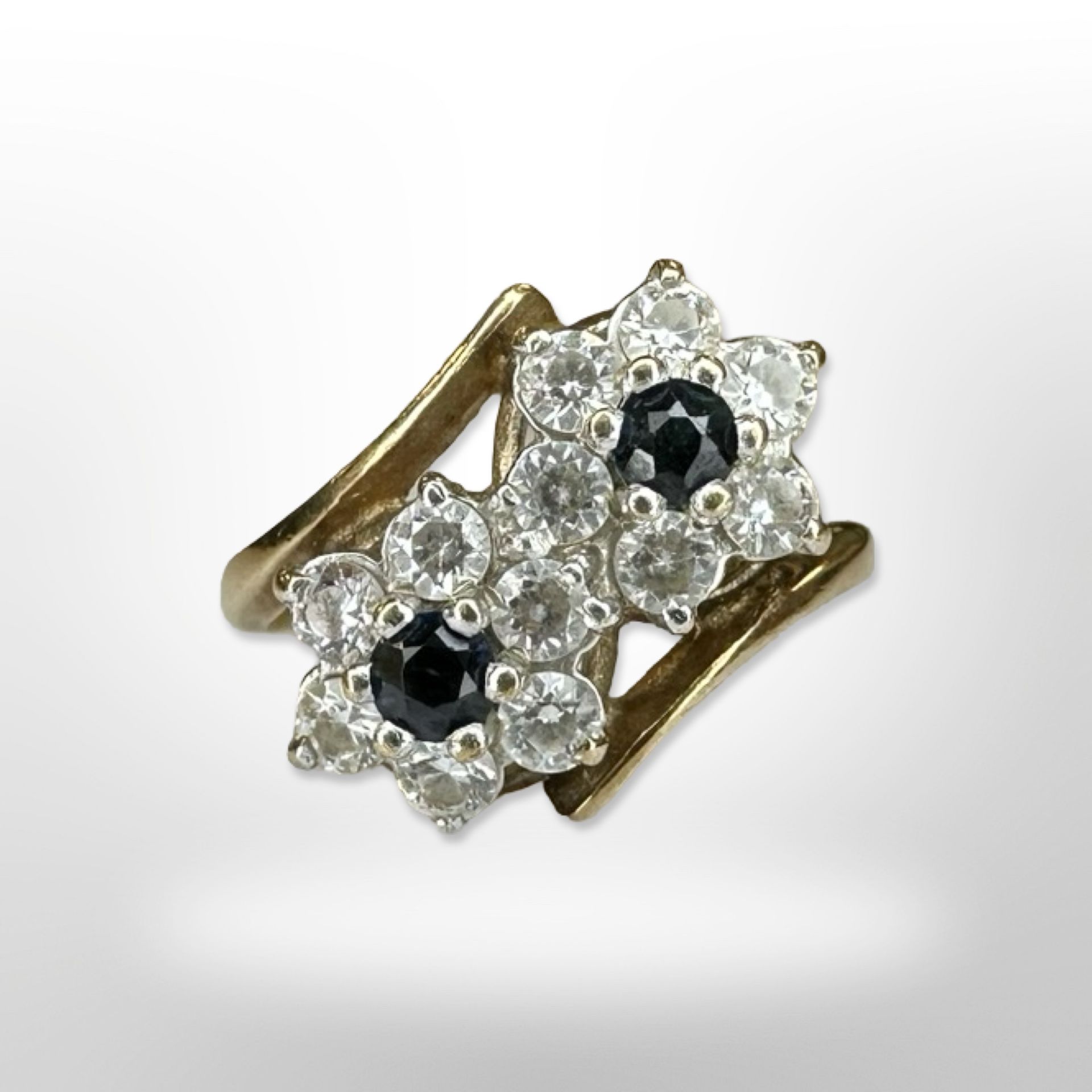 A 9ct yellow gold sapphire and zircon cluster ring with double flower head, size L.