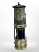 A 19th-century brass and steel miner's lamp.