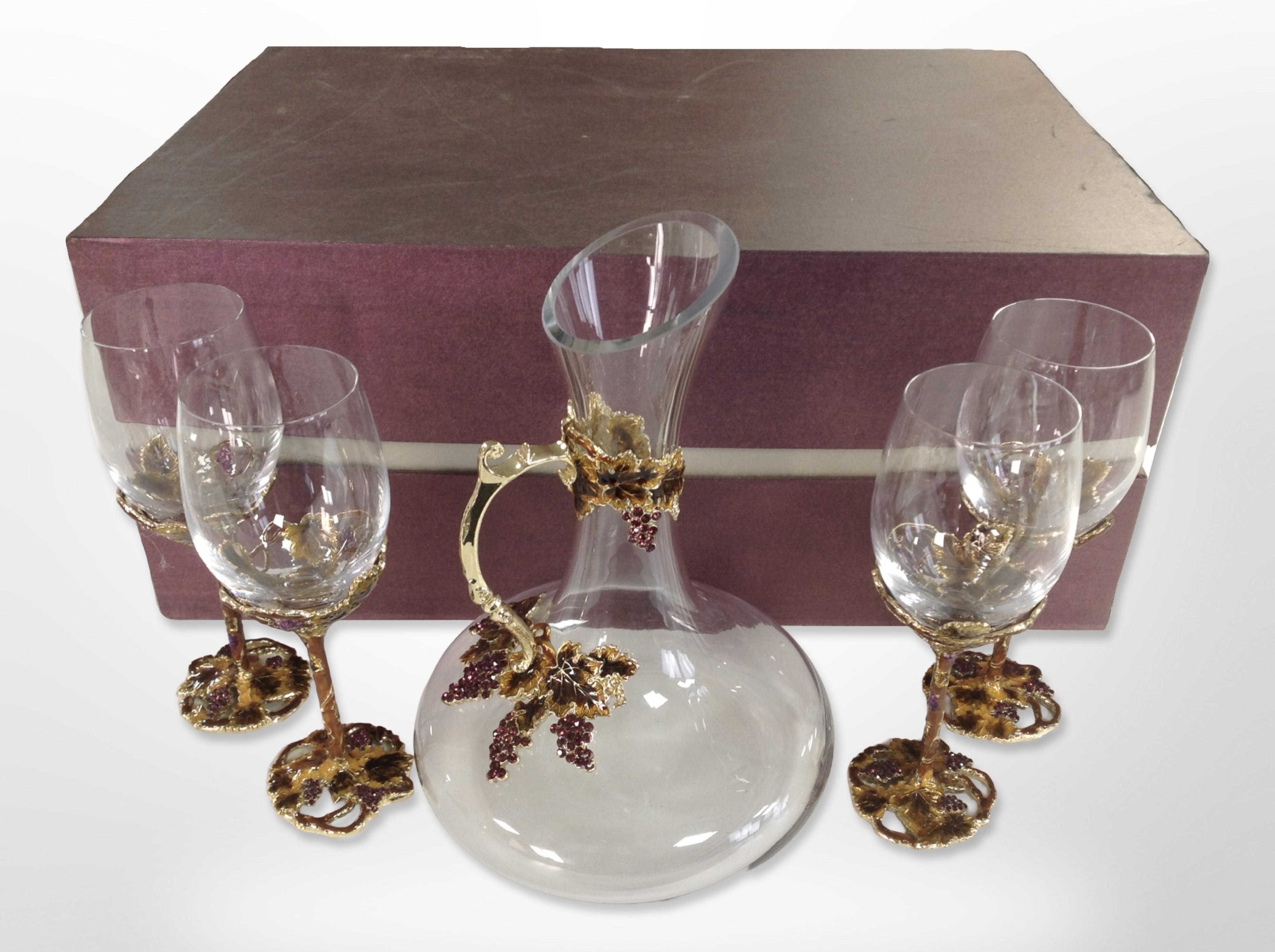 A set of four contemporary crystal and enamelled metal grape and leaf pattern wine glasses with