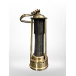 A reproduction brass miner's lamp with steel gauze centre.