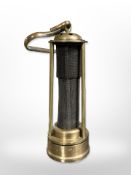 A reproduction brass miner's lamp with steel gauze centre.