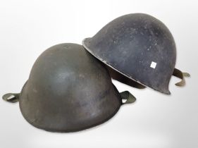 Two 20th-century military tin helmets.