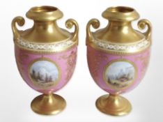 A pair of twin-handled gilt porcelain urns, hand-painted with landscapes, height 13.5cm.