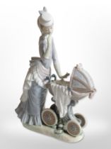 A Lladró figure of a lady with a baby in a pram,