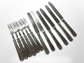 A set of silver-handled cake knives and forks.