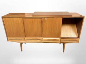 A 20th century Danish teak sliding door sideboard, fitted with four drawers raised on tapering legs,