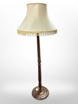 A turned beech standard lamp with tasseled shade