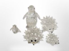 Two Swarovski crystal penguin ornaments and three hedgehogs, tallest 7.5cm.