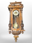 An early-20th century walnut Vienna wall clock with enamelled dial, height 86cm.