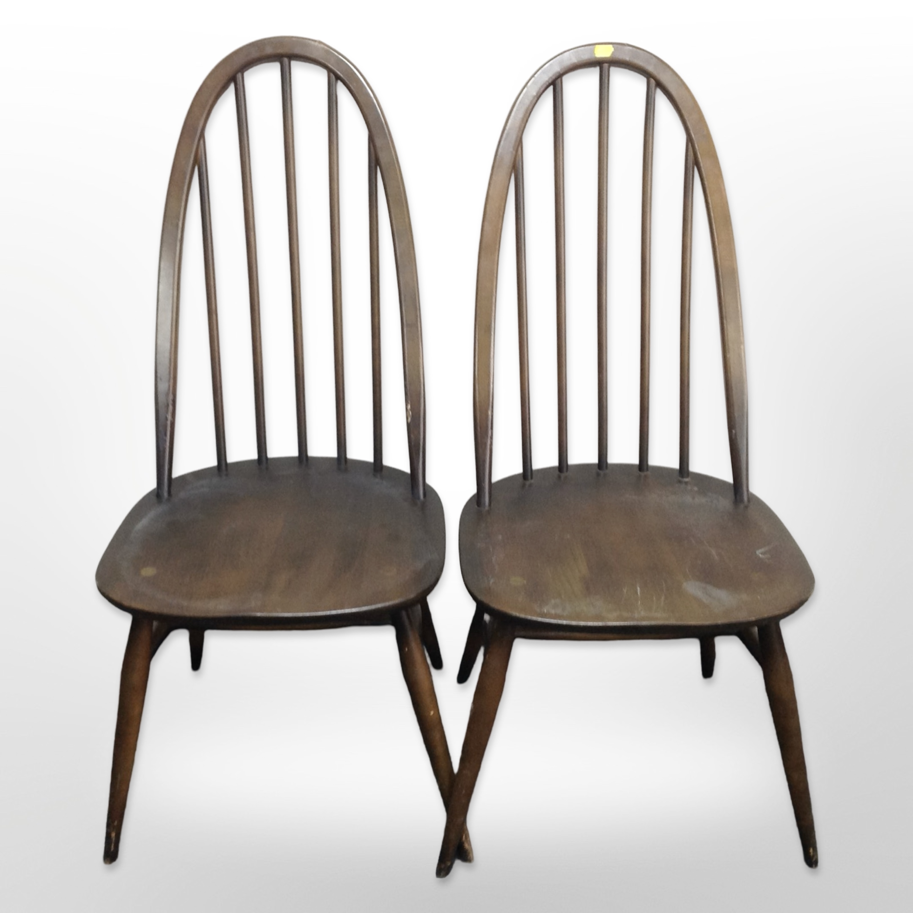 A pair of Ercol stained spindle backed dining chairs