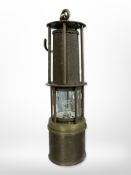 A brass miner's Davy lamp with gauze centre.
