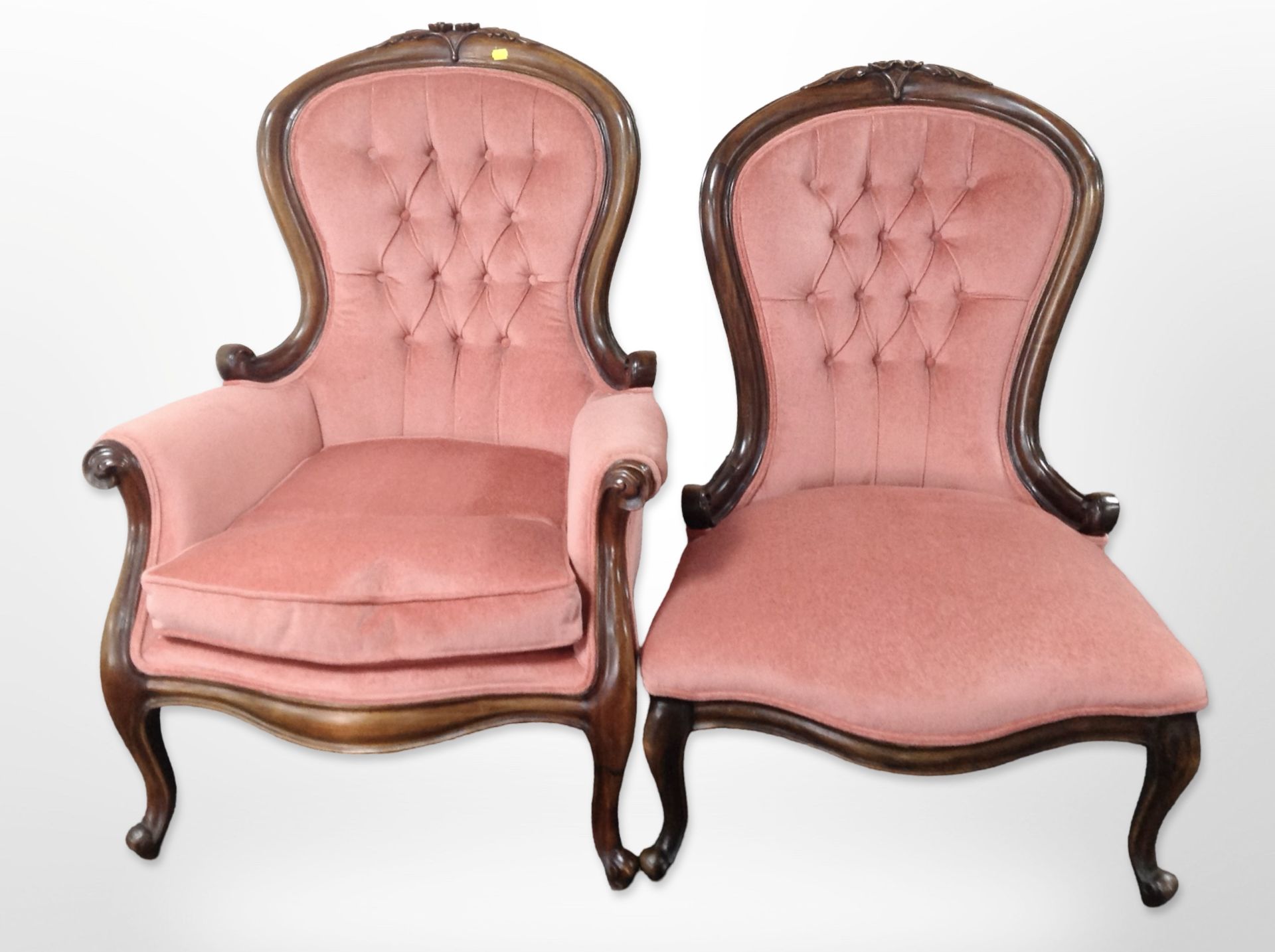 A pair of Victorian style carved mahogany lady's and a gent's armchairs in pink buttoned dralon