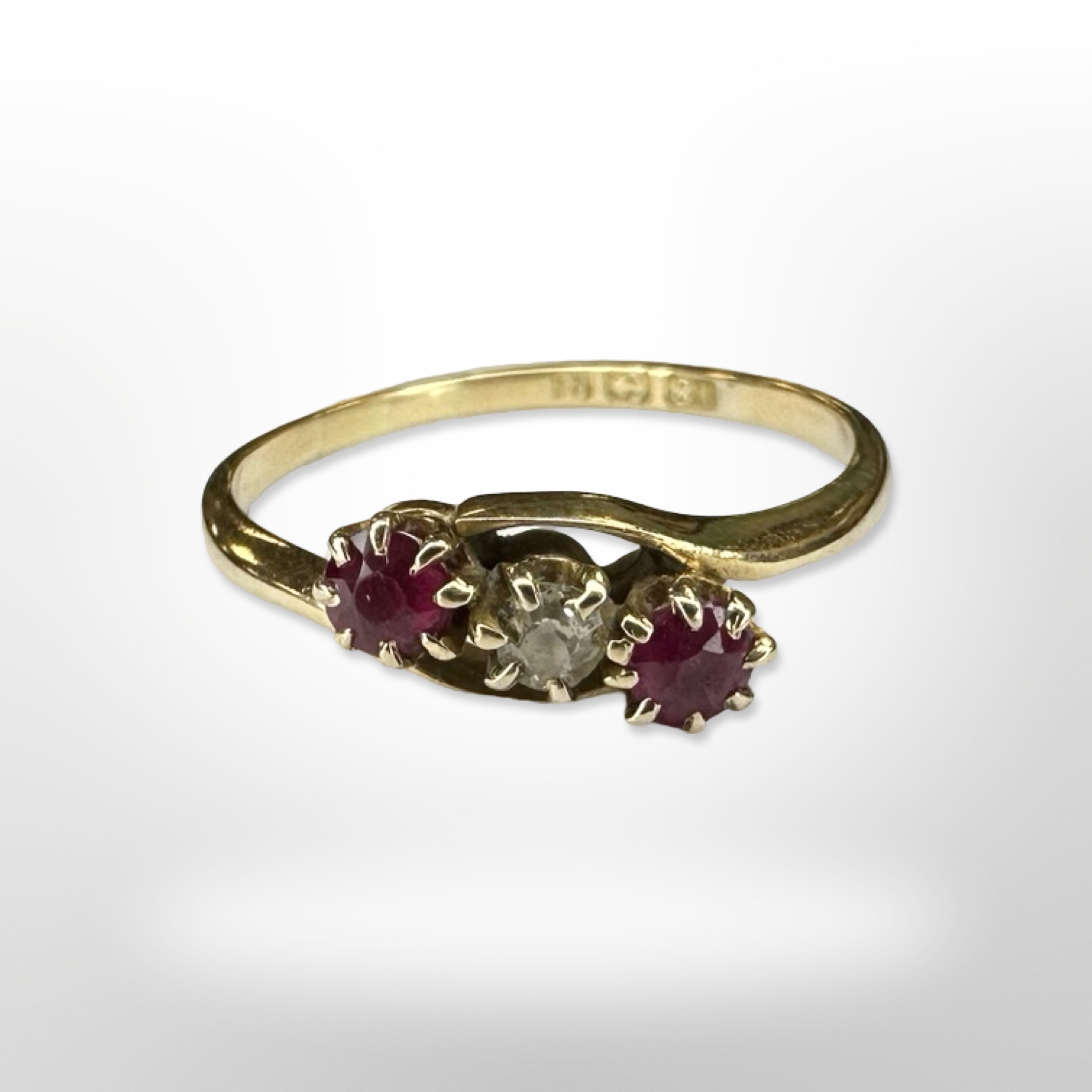 An 18ct yellow gold two stone ruby and diamond ring, size N. CONDITION REPORT: 2g.