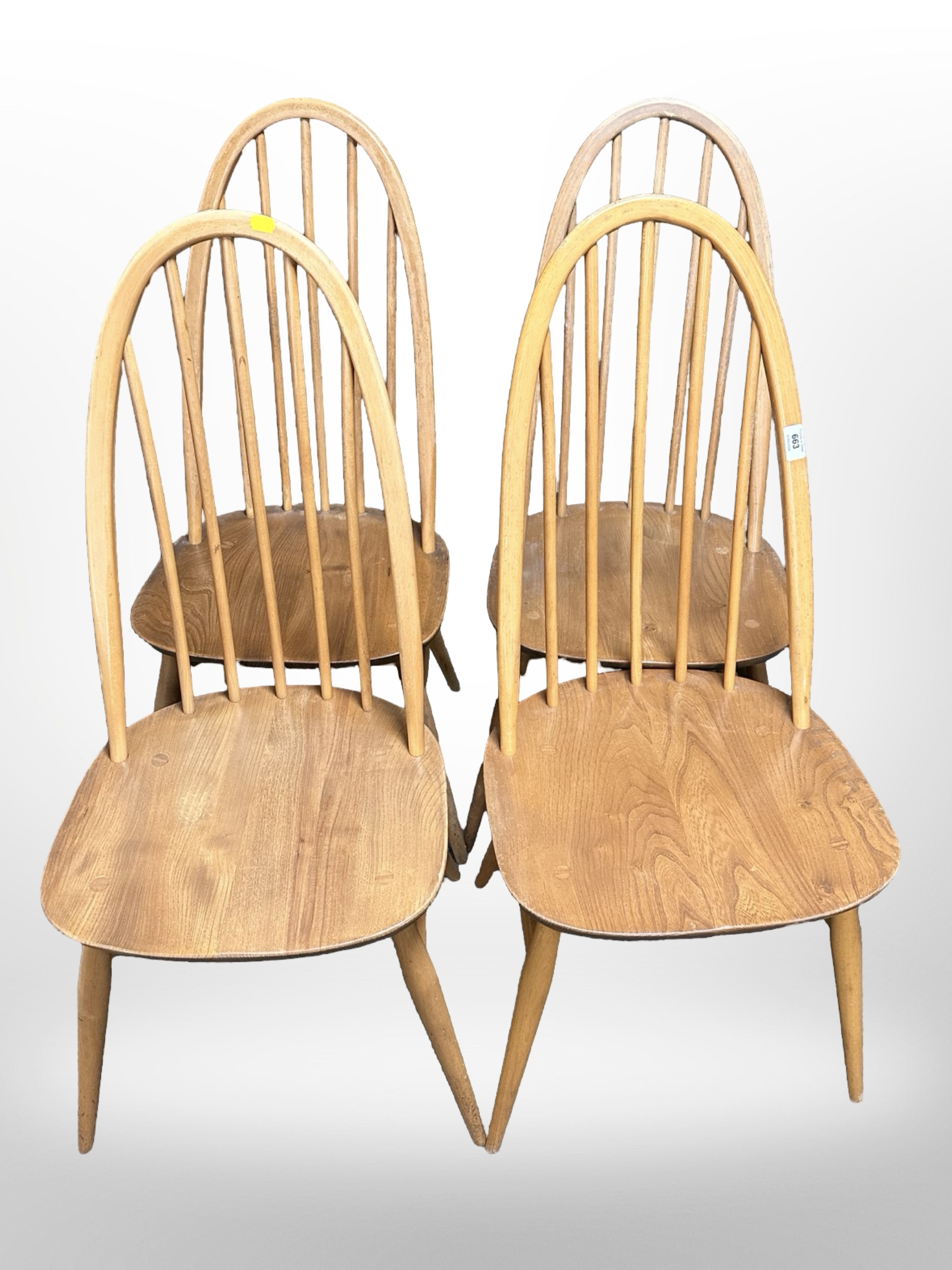 A set of four Ercol light elm and beech spindle backed dining chairs