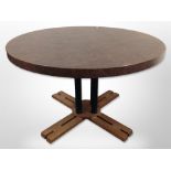 A contemporary MDF circular dining table with X-shaped pedestal base and leather effect top,