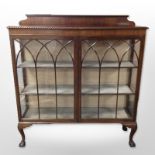 An early 20th century mahogany double door display cabinet on claw and ball feet,