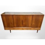 A 20th century Danish teak sliding door sideboard, fitted four drawers beneath on tapering legs,