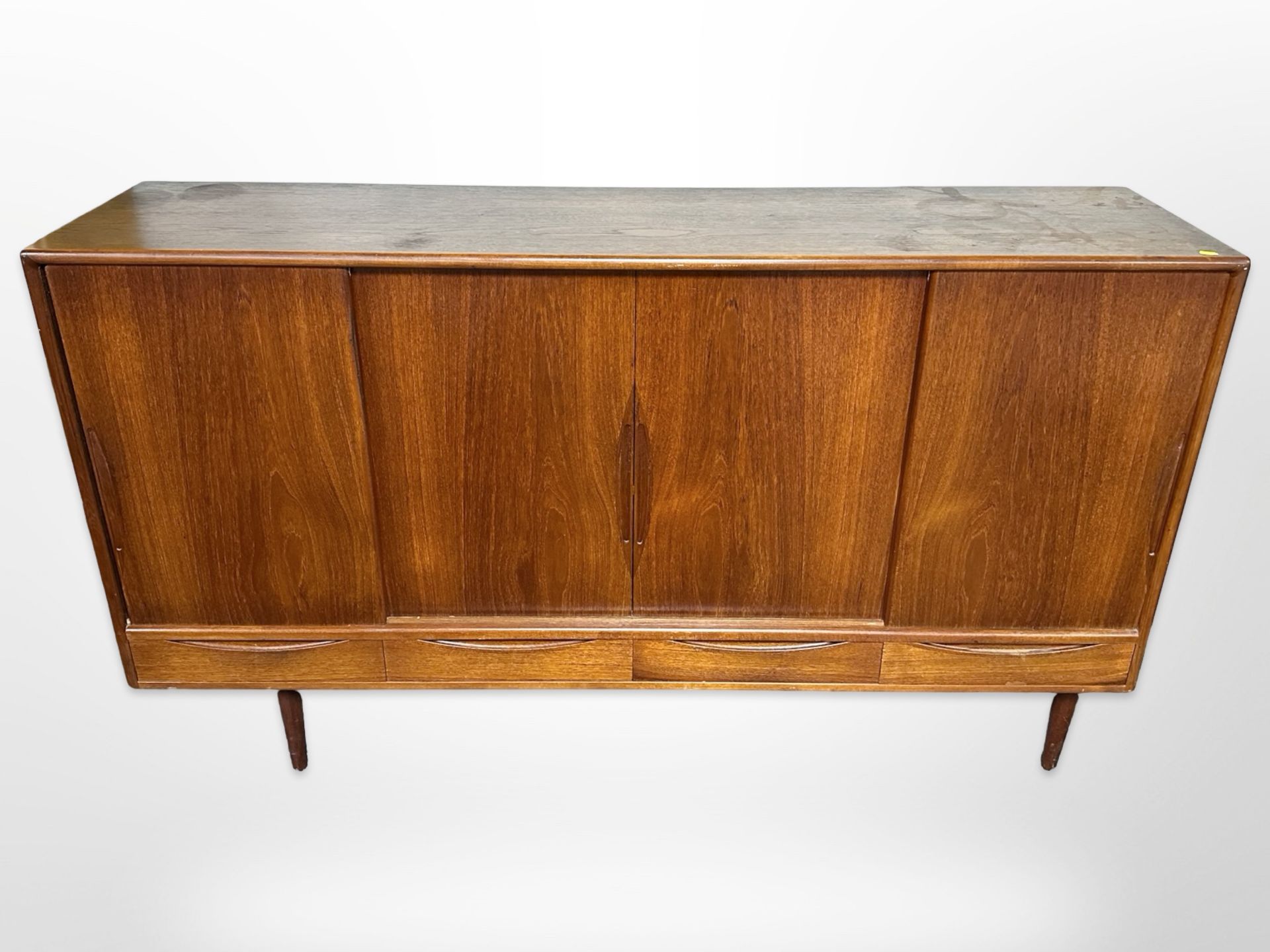 A 20th century Danish teak sliding door sideboard, fitted four drawers beneath on tapering legs,