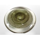 An art glass discus-form sculpture, diameter 22cm, with flat standing edge on one side.