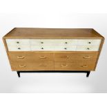 A vintage G Plan oak and teak ten drawer sideboard, designed by E Gomme, raised on ebonised legs,
