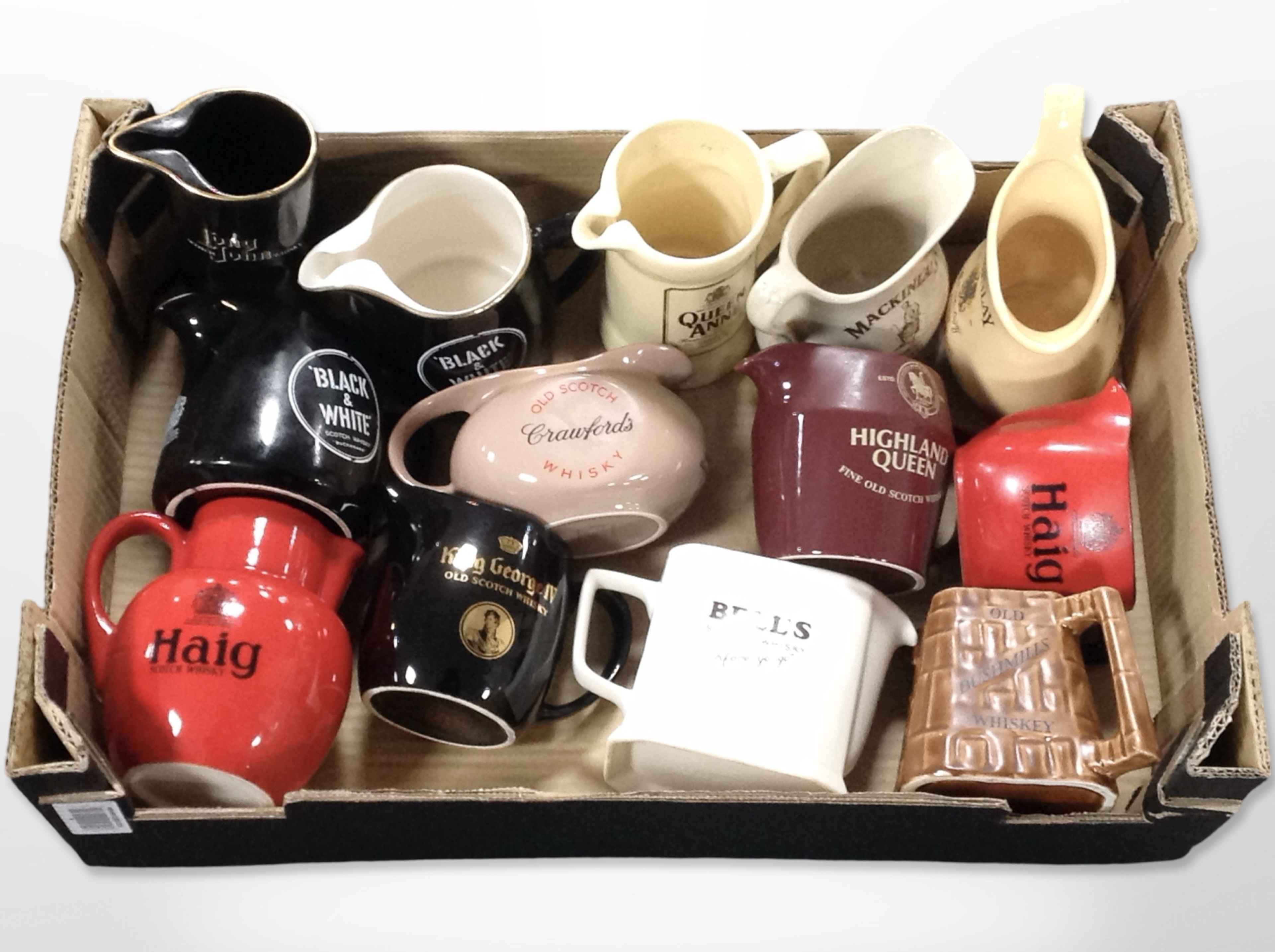 A collection of ceramic whisky jugs bearing various advertising.