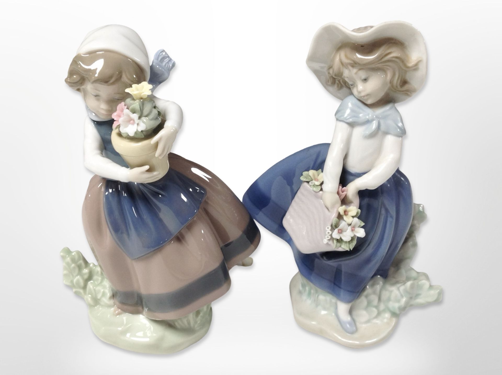 Two Lladró figures of girls carrying baskets of flowers, height 18cm.