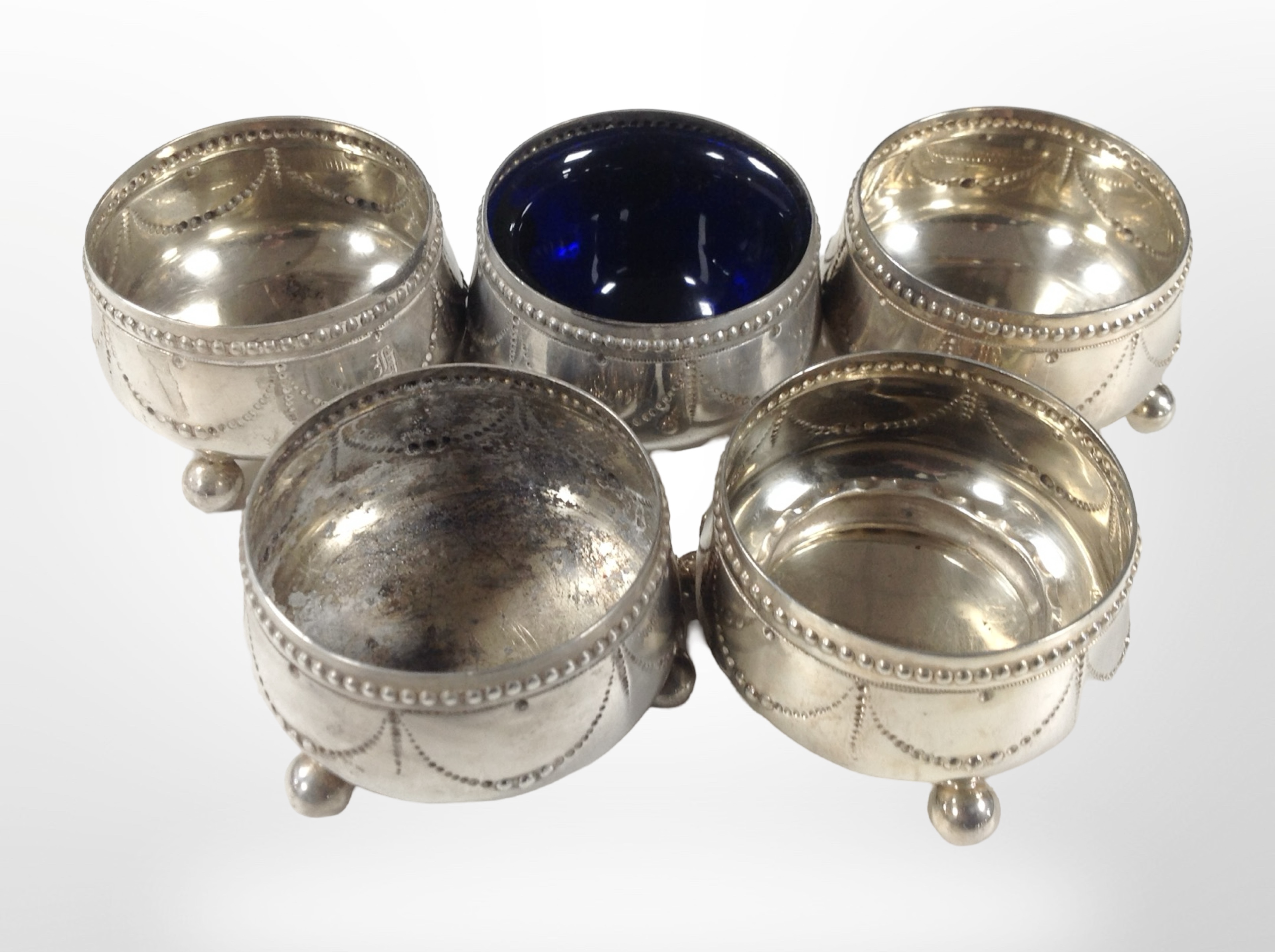 A group of five silver salts, one with blue-glass liner, together with a small silver napkin ring.