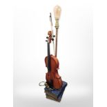 A contemporary table lamp in the form of a violin on top of a stack of books,